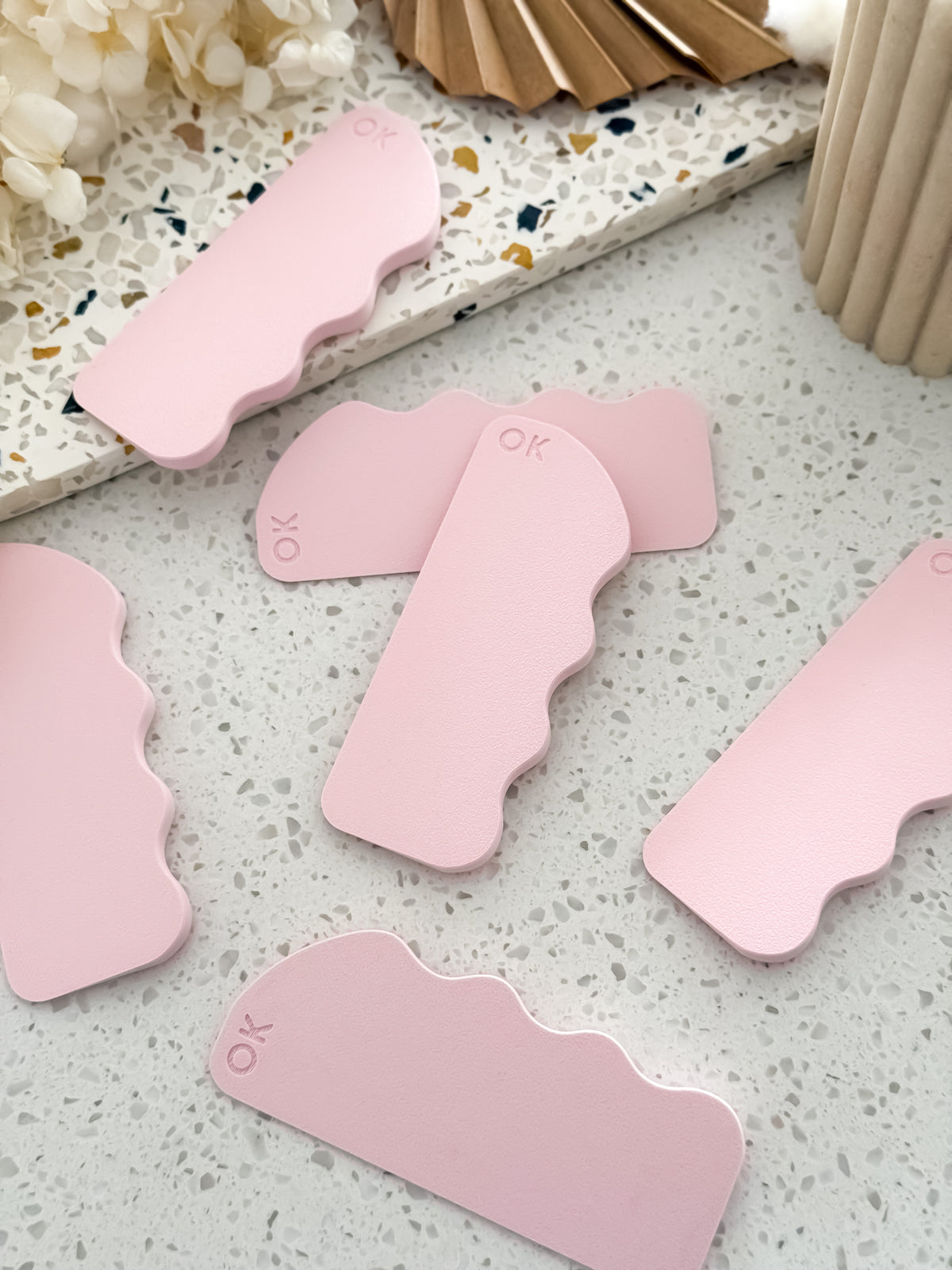 Scrape Pro™ fondant scrapers by O'Khach with wavy palm-fitting edge and embossed OK logo